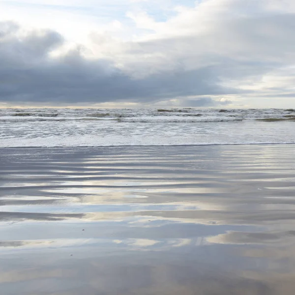 Fırtınadan sonra Baltık Denizi. Yumuşak günbatımı ışığı, çarpıcı parlayan bulutlar. Deniz manzarası, bulutlar, doğa. Sudaki yansımalar. Panoramik manzara. Ekoloji, iklim değişikliği, hava durumu