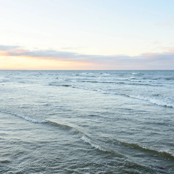 Gün batımında Baltık kıyılarından panoramik manzara. Dramatik bulutlar, parlayan bulutlar, fırtınadan sonra altın güneş ışığı. Doğa, çevre, iklim değişikliği, kararsız hava
