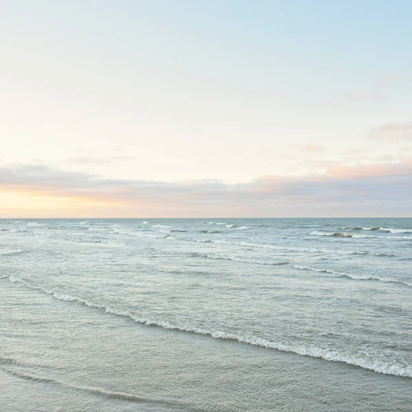 Gün batımında Baltık kıyılarından panoramik manzara. Dramatik bulutlar, parlayan bulutlar, fırtınadan sonra altın güneş ışığı. Doğa, çevre, iklim değişikliği, kararsız hava