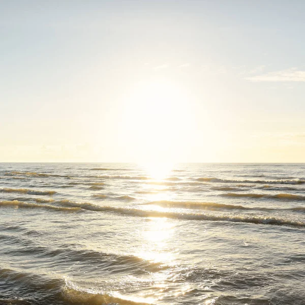 Kumlu bir sahilden (kum tepeleri) Baltık denizinin panoramik görüntüsü. Parlayan bulutlarla, dalgalarla ve su sıçramalarıyla berrak bir gökyüzü. Idyllic deniz manzarası. Sıcak kış havası, iklim değişikliği, doğa
