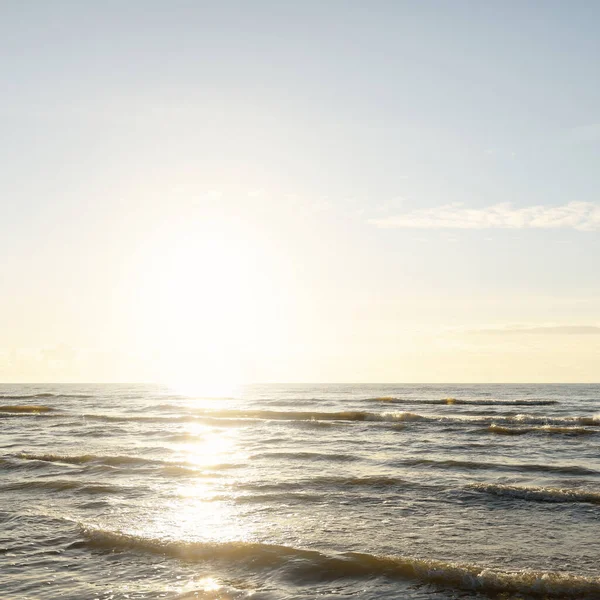 Kumlu bir sahilden (kum tepeleri) Baltık denizinin panoramik görüntüsü. Parlayan bulutlarla, dalgalarla ve su sıçramalarıyla berrak bir gökyüzü. Idyllic deniz manzarası. Sıcak kış havası, iklim değişikliği, doğa