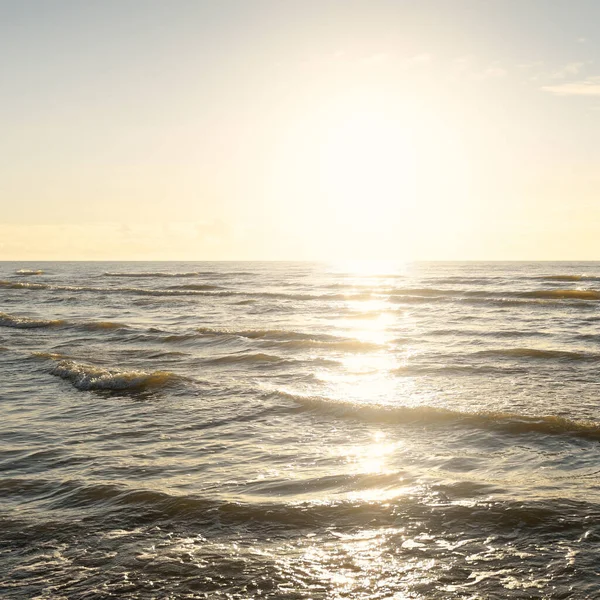 Kumlu bir sahilden (kum tepeleri) Baltık denizinin panoramik görüntüsü. Parlayan bulutlarla, dalgalarla ve su sıçramalarıyla berrak bir gökyüzü. Idyllic deniz manzarası. Sıcak kış havası, iklim değişikliği, doğa