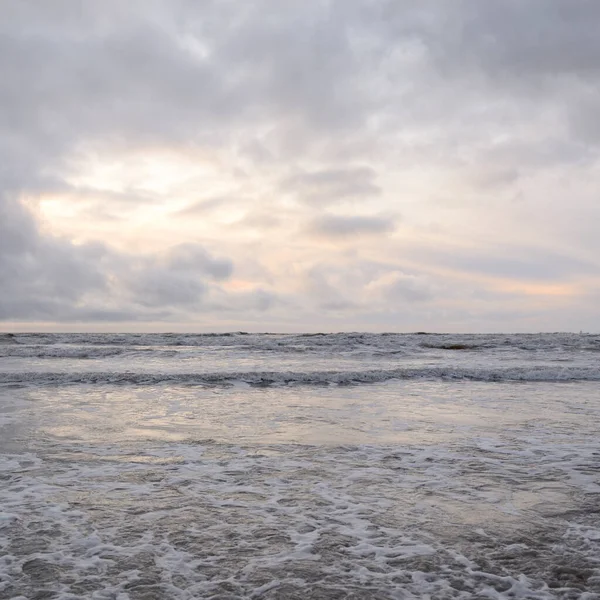 Fırtınadan sonra Baltık Denizi. Yumuşak günbatımı ışığı, çarpıcı parlayan bulutlar. Deniz manzarası, bulutlar, doğa. Sudaki yansımalar. Panoramik manzara. Ekoloji, iklim değişikliği, hava durumu