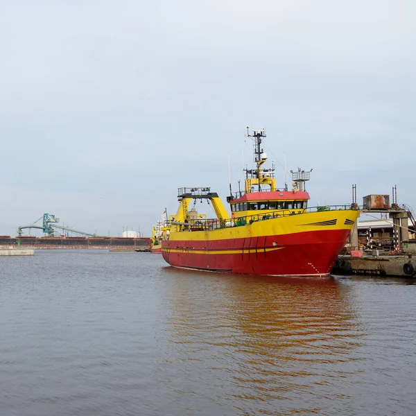 Balıkçı teknesi (trol teknesi) kargo limanına demir attı. Baltık Denizi, Ventspils, Letonya. Ulaşım, geleneksel zanaat, lojistik, endüstri, özel ekipman