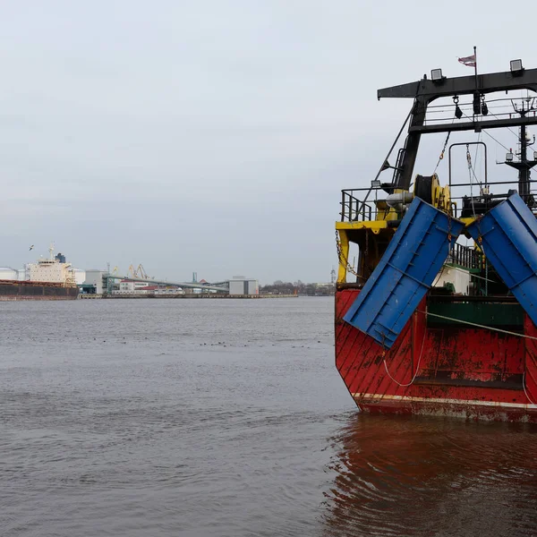 Balıkçı teknesi (trol teknesi) kargo limanına demir attı. Baltık Denizi, Ventspils, Letonya. Ulaşım, geleneksel zanaat, lojistik, endüstri, özel ekipman
