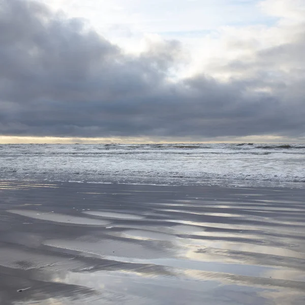 Fırtınadan sonra Baltık Denizi. Yumuşak günbatımı ışığı, çarpıcı parlayan bulutlar. Deniz manzarası, bulutlar, doğa. Sudaki yansımalar. Panoramik manzara. Ekoloji, iklim değişikliği, hava durumu