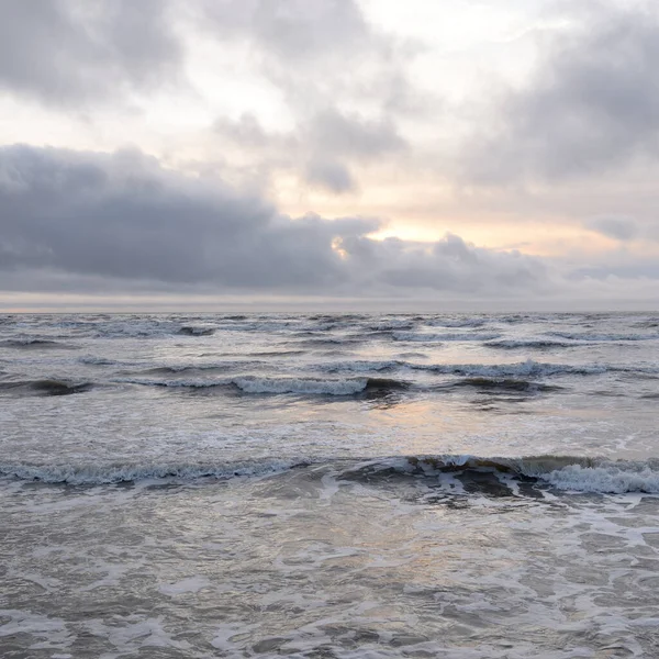 Fırtınadan sonra Baltık Denizi. Yumuşak günbatımı ışığı, çarpıcı parlayan bulutlar. Deniz manzarası, bulutlar, doğa. Panoramik manzara. Ekoloji, iklim değişikliği, hava durumu
