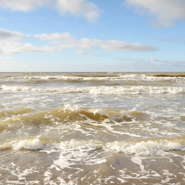 Fırtınadan sonra Baltık Denizi. Dramatik gökyüzü, parlayan bulutlar, yumuşak güneş ışığı. Dalgalar, su sıçratma. Resimli manzara, deniz manzarası, doğa. Panoramik görünüm