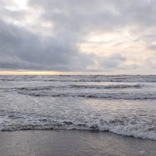Fırtınadan sonra Baltık Denizi. Yumuşak günbatımı ışığı, çarpıcı parlayan bulutlar. Deniz manzarası, bulutlar, doğa. Sudaki yansımalar. Panoramik manzara. Ekoloji, iklim değişikliği, hava durumu