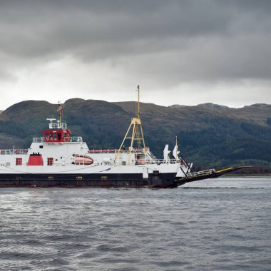 Ro-ro yolcu gemisi bulutlu bir günde kayalık göl kıyısında yol alıyor. Rothesay, İskoçya, İngiltere. Denizcilik gemisi, ulaşım, feribot bağlantısı, seyahat, turizm temaları