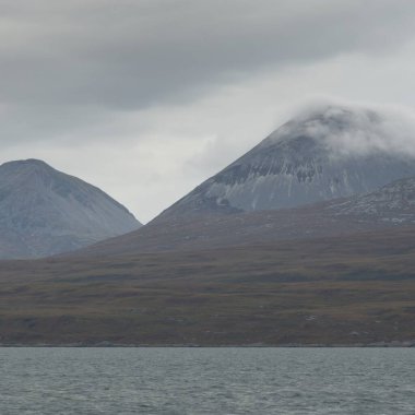 Rocky gölü kıyıları, dağ zirveleri, dağlar, vadiler ve tepeler. Yelkenliden panoramik manzara. Dramatik bir gökyüzü. İskoçya, İngiltere. Atmosferik manzara. Seyahat yerleri, dönüm noktaları, yürüyüş, eko-turizm