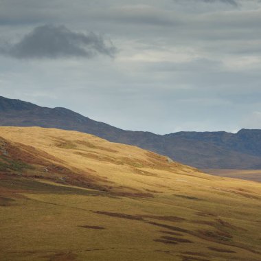 Jura adasının dağ tepeleri, vadiler ve tepeleri. Panoramik manzara. Dramatik bir gökyüzü. İskoçya, İngiltere. Atmosferik manzara. Seyahat noktaları, sınır işaretleri, yürüyüş, eko-turizm, çevre koruma