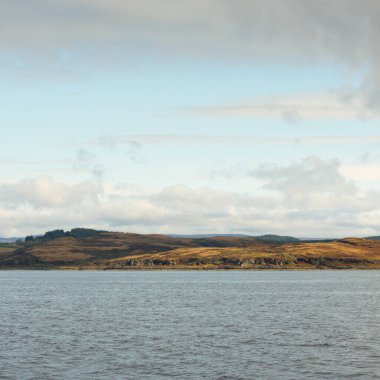 İskoçya, Rothesay 'ın kayalık kıyıları, tepeleri ve vadileri üzerinde dramatik bir gökyüzü. Yelkenliden panoramik manzara. Seyahat merkezleri, turizm, yürüyüş, dönüm noktası, ekoloji, çevre, doğa temaları