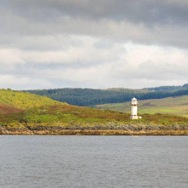 İskoçya, Rothesay 'ın kayalık kıyıları, tepeleri ve vadileri üzerinde dramatik bir gökyüzü. Yelkenliden panoramik manzara. Seyahat merkezleri, turizm, yürüyüş, dönüm noktası, ekoloji, çevre, doğa temaları