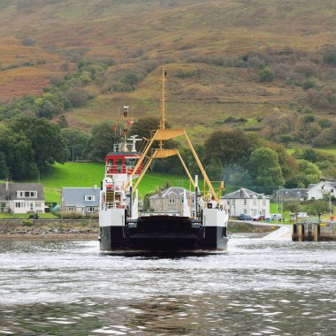 Ro-ro yolcu gemisi bulutlu bir günde kayalık göl kıyısında yol alıyor. Rothesay, İskoçya, İngiltere. Denizcilik gemisi, ulaşım, feribot bağlantısı, seyahat, turizm temaları