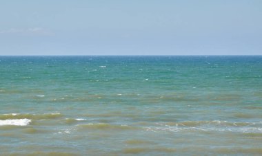 Güneşli bir günde Baltık Denizi kıyısı. Kumlu kumsal kumullarından görüntü). Açık mavi gökyüzü, turkuaz su. Idyllic deniz manzarası, manzara. Saf doğa, ekoloji, eko turizm, tatiller. İlkbahar, yazın başı