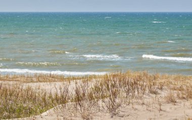 Güneşli bir günde Baltık Denizi kıyısı. Kumlu kumsal kumullarından görüntü). Açık mavi gökyüzü, turkuaz su. Idyllic deniz manzarası, manzara. Saf doğa, ekoloji, eko turizm, tatiller. İlkbahar, yazın başı