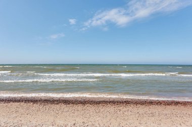 Güneşli bir günde Baltık Denizi kıyısı. Kumlu kumsal kumullarından görüntü). Açık mavi gökyüzü, turkuaz su. Idyllic deniz manzarası, manzara. Saf doğa, ekoloji, eko turizm, tatiller. İlkbahar, yazın başı