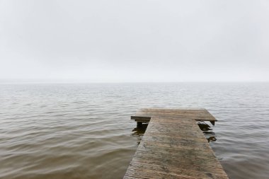 Kalın bir siste Busnieku Gölü. Letonya 'da sızıntı var. Ahşap iskele. Kasvetli gökyüzü, yağmur. Bulutlu bir gün. Idyllic manzara, kırsal manzara. Doğa, ekoloji, eko-turizm, yürüyüş, ekoloji beldesi, yerel turizm