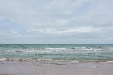 Fırtınadan sonra Baltık kıyıları. Yumuşak güneş ışığı. Su yüzeyi dokusu, çarpan dalgalar ve sıçramalar, köpük. Resimli panoramik manzara. Idyllic deniz manzarası. Doğa, çevre, ekoloji