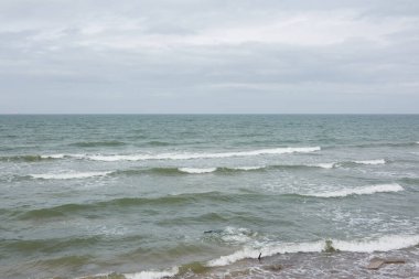 Fırtınadan sonra Baltık kıyıları. Yumuşak güneş ışığı. Su yüzeyi dokusu, çarpan dalgalar ve sıçramalar, köpük. Resimli panoramik manzara. Idyllic deniz manzarası. Doğa, çevre, ekoloji