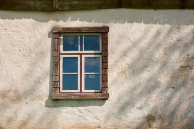 Eski bir taş ev. Kırmızı kiremit çatı, ahşap detaylar. Yeşil bahçe. İlkbahar, yazın başı. Idyllic kırsal kesim. Mimarlık, dış tasarım, inşa gelenekleri, kırsal yaşam, turizm temaları