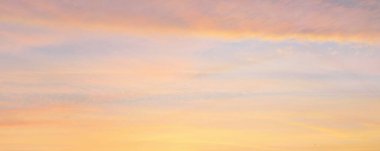 Parlayan pembe, altın rengi sirrus ve kümülüs bulutlarıyla açık mavi gökyüzü. Gün doğumu. Dramatik bulut manzarası. Sanat, meteoroloji, cennet, umut, barış, grafik kaynakları, resimli panoramik manzara