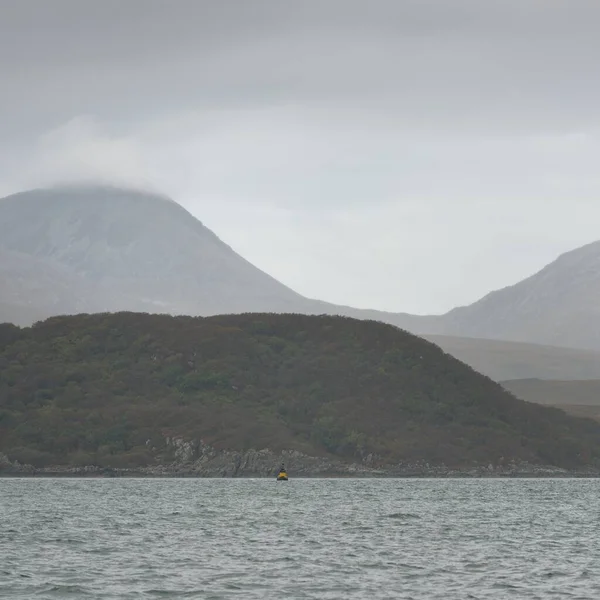 Rocky gölü kıyıları, dağ zirveleri, dağlar, vadiler ve tepeler. Yelkenliden panoramik manzara. Dramatik bir gökyüzü. İskoçya, İngiltere. Atmosferik manzara. Seyahat yerleri, dönüm noktaları, yürüyüş, eko-turizm