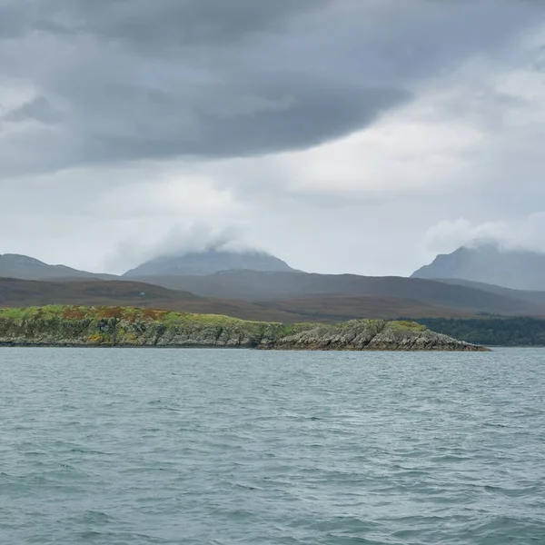 Rocky gölü kıyıları, dağ zirveleri, dağlar, vadiler ve tepeler. Yelkenliden panoramik manzara. Dramatik bir gökyüzü. İskoçya, İngiltere. Atmosferik manzara. Seyahat yerleri, dönüm noktaları, yürüyüş, eko-turizm