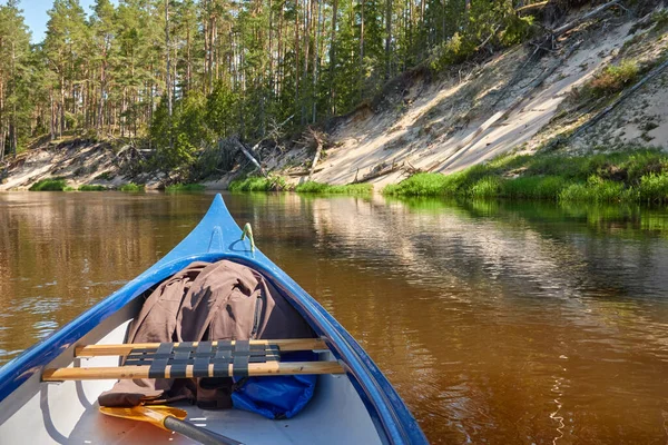 Canoe riding on Irbe river. Kurzeme, Latvia. Sandy shore, evergreen pine forest. Nature, ecology, eco tourism, hiking, leisure activity, boating, rowing, sport, healthy lifestyle, wanderlust