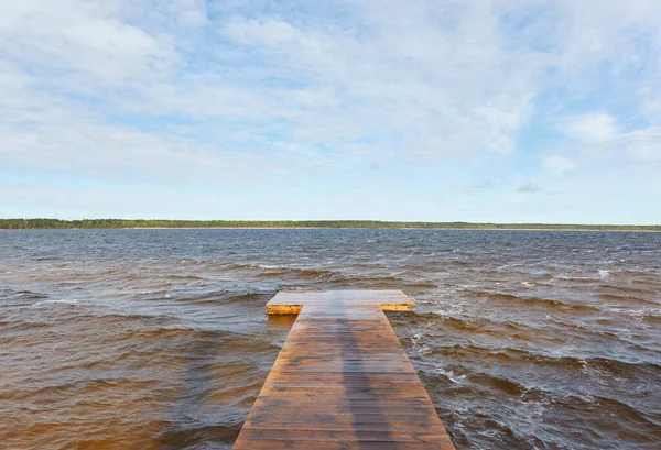 Güneşli bir günde, bir orman gölünde (nehir) bir ada. Sudaki yansımalar. Mavi gökyüzü, parlayan bulutlar. Idyllic manzara. Saf doğa, ekoloji, ekolojik rezerv, eko-turizm.