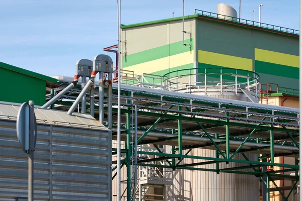 Modern grain elevator in cargo port. Ventspils, Latvia. Concept urban landscape. Nature, ecology, biotechnology, rapeseed fuel, environmental conservation, ecological damage themes