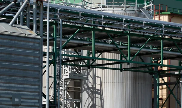 Modern grain elevator in cargo port. Ventspils, Latvia. Concept urban landscape. Nature, ecology, biotechnology, rapeseed fuel, environmental conservation, ecological damage themes