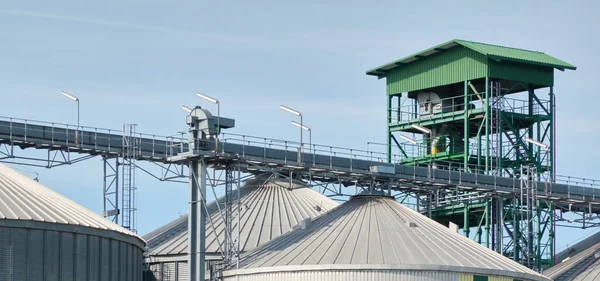 Modern grain elevator in cargo port. Ventspils, Latvia. Concept urban landscape. Nature, ecology, biotechnology, rapeseed fuel, environmental conservation, ecological damage themes