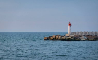 Fırtınadan sonra Baltık Denizi. Deniz fenerine doğru ilerleyin. Dalgalar. Dramatik gökyüzü, bulutlar, gece yarısı güneşi. Resimli rüya gibi deniz manzarası, bulut manzarası. Doğa, seyahat yerleri. Panoramik görünüm