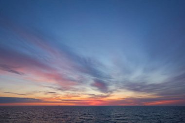 Gün batımında Baltık Denizi. Dramatik gökyüzü, mavi ve pembe parlayan bulutlar, yumuşak altın güneş ışığı, gece yarısı güneşi. Alacakaranlık, yaz gecesi. Deniz manzarası, bulut manzarası, doğa. Panoramik görünüm