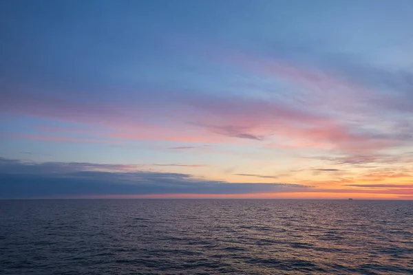 Baltic sea at sunset. Dramatic sky, blue and pink glowing clouds, soft golden sunlight, midnight sun. Twilight, summer night. Picturesque dreamlike seascape, cloudscape, nature. Panoramic view