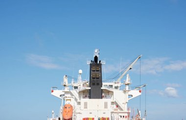 Liman terminaline büyük bir kargo gemisi yükleniyor. Yük taşımacılığı, deniz taşımacılığı, lojistik, küresel iletişim, dünya çapında taşımacılık, ekonomi, ticaret, sanayi