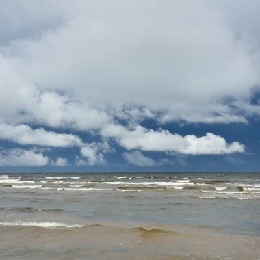 Fırtınadan sonra Baltık Denizi. Koyu mavi gökyüzü, çarpıcı parlayan bulutlar. Deniz manzarası, bulutlar, doğa. Panoramik manzara. Ekoloji, iklim değişikliği, hava durumu, tehlike