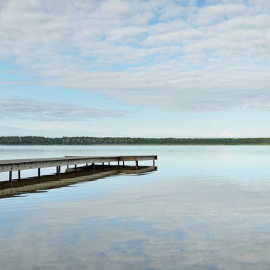 Orman nehri (göl) güneşli bir günde. Ahşap iskele. Clea gökyüzü, kristal berrak suda yansıyor. Idyllic manzara, kırsal manzara. Doğa, ekoloji, eko-turizm, yürüyüş, ekoloji beldesi, yerel turizm