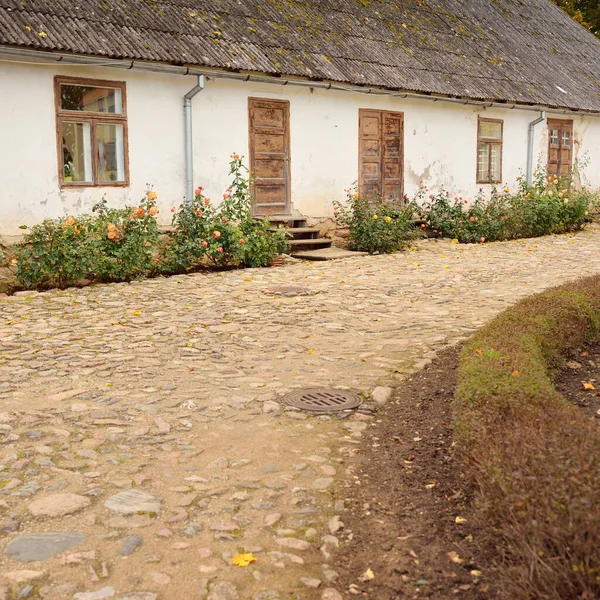素朴な木製のドアと窓のある伝統的な石造りの家 開花するバラの花 美しい庭 牧歌的な田園風景 旅行先 地元の観光 ランドマーク ガーデニング — ストック写真