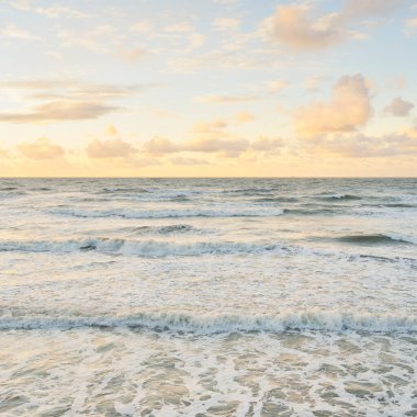 Deniz dalgaları ve sıçrama dokusu. Renkli gökyüzü suya yansıyor. Idyllic deniz manzarası. Kavramsal görüntü, uzun pozlama. Resimli bir manzara var. Arkaplan, duvar kağıdı, doğal desen, grafik kaynakları