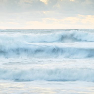 Deniz dalgaları ve sıçrama dokusu. Renkli gökyüzü suya yansıyor. Idyllic deniz manzarası. Kavramsal görüntü, uzun pozlama. Resimli bir manzara var. Arkaplan, duvar kağıdı, doğal desen, grafik kaynakları