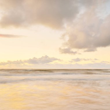 Deniz dalgaları ve sıçrama dokusu. Renkli gökyüzü suya yansıyor. Idyllic deniz manzarası. Kavramsal görüntü, uzun pozlama. Resimli bir manzara var. Arkaplan, duvar kağıdı, doğal desen, grafik kaynakları