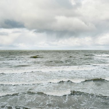 Fırtınadan sonra dramatik günbatımı bulutları altında Baltık Denizi. Dalgalar, su sıçratma. Destansı deniz manzarası. 40-50 deniz mili rüzgar gücü. Kasırga, fırtına, sert hava, meteoroloji, ekoloji, iklim değişikliği