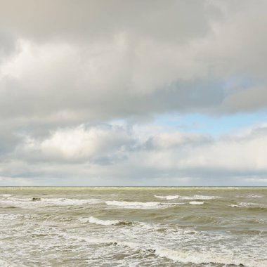 Fırtınadan sonra dramatik günbatımı bulutları altında Baltık Denizi. Dalgalar, su sıçratma. Destansı deniz manzarası. Kasırga, fırtına, sert hava, meteoroloji, ekoloji, iklim değişikliği, doğal olaylar