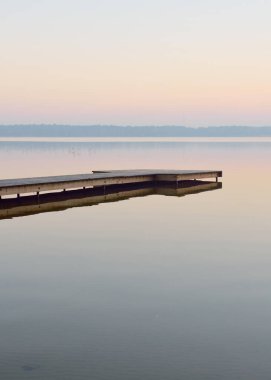Orman Gölü (nehir) gün doğumunda. Tahta iskele (tahta iskele). Yumuşak güneş ışığı, sisler, suya yansıyan yansımalar. Idyllic sonbahar manzarası. Saf doğa, eko-turizm, yürüyüş, keşif.