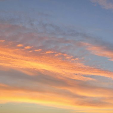 Açık mavi gökyüzü. Pembe ve altın renkli bulutlar. Gün doğumu. Dramatik bulut manzarası. Sanat, meteoroloji, cennet, umut, barış, grafik kaynakları, resimli panoramik manzara
