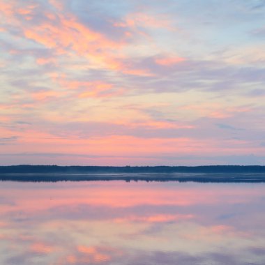 Orman nehri (göl) gün doğumunda. Sis, yumuşak güneş ışığı. Açık gökyüzü, renkli parlayan bulutlar. Dramatik bulut manzarası. Simetri suya yansıyor. Resimli panoramik manzara. Saf doğa, çevre