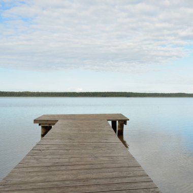 Orman nehri (göl) güneşli bir günde. Ahşap iskele. Clea gökyüzü, kristal berrak suda yansıyor. Idyllic manzara, kırsal manzara. Doğa, ekoloji, eko-turizm, yürüyüş, ekoloji beldesi, yerel turizm